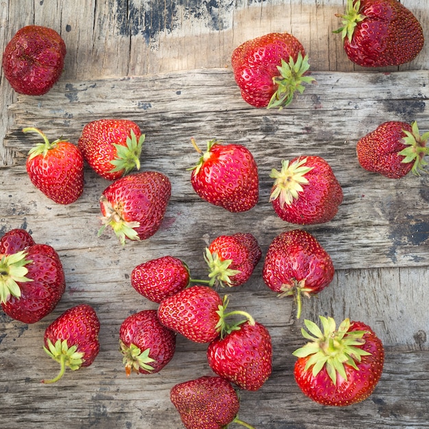 Eine große rote reife Erdbeere auf einem hölzernen Brett