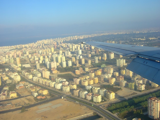 Eine große Stadt mit vielen niedrigen Gebäuden unter den Flügeln eines Flugzeugs