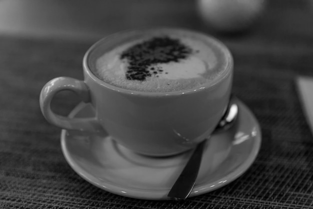 Eine große Tasse Cappuccino mit Zimt auf einem Tisch in einem Café Guten Morgen Nahaufnahme Schwarz-Weiß-Foto