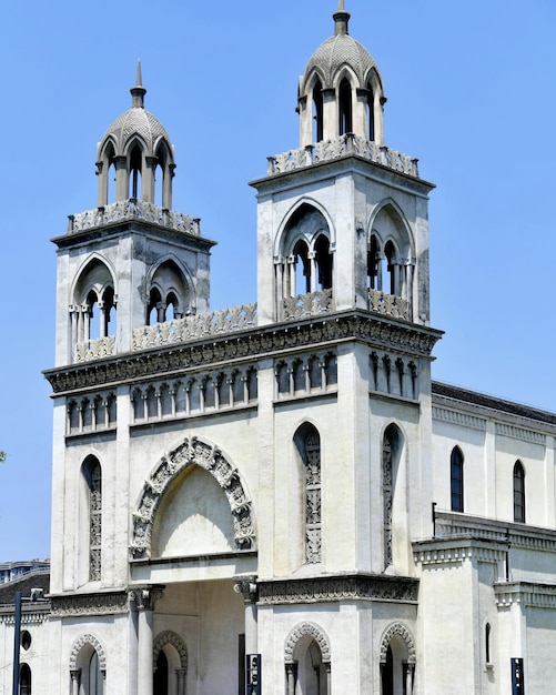 Eine große weiße Kirche mit einem großen Turm mit zwei Türmen und einem Kreuz auf der Spitze.