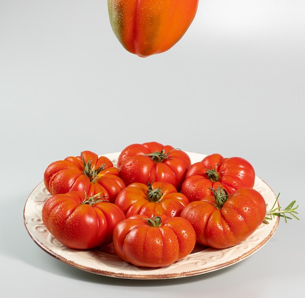 Eine Gruppe Costoluto große Tomaten und Paprika mit Rosmarin auf weißem Hintergrund Platz für Text