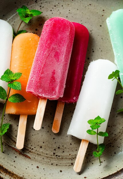 Eine Gruppe farbiger Eiscreme auf einem Stock auf einem weißen Sommerdessert