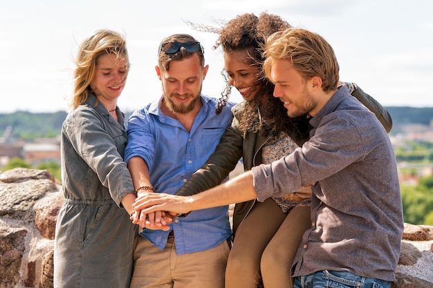 Eine Gruppe fröhlicher Freunde hält sich an den Händen. Zusammengehörigkeitskonzept