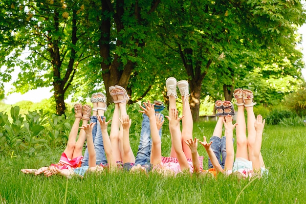Eine Gruppe glückliche Kinder von Jungen und von Mädchen laufen in den Park auf dem Gras an einem sonnigen Sommertag.