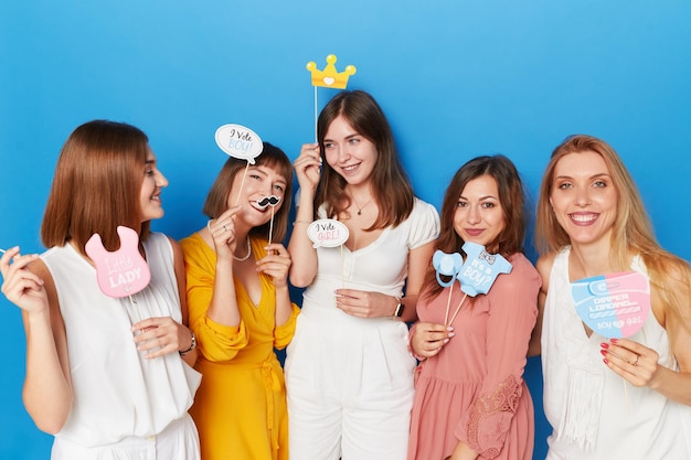 Eine Gruppe glücklicher Frauen, die Geschlecht haben, zeigt einen isolierten blauen Hintergrund