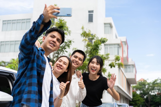 Eine Gruppe glücklicher junger asiatischer Studenten macht Selfies und Videos mit Smartphones zusammen für Vlogs