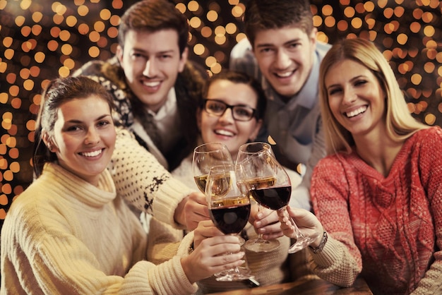 Eine Gruppe glücklicher junger Leute trinkt Wein im Party-Disco-Restaurant