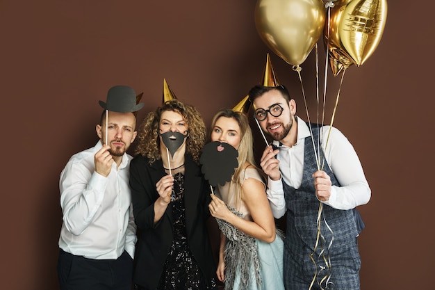 Foto eine gruppe glücklicher menschen, die partyhüte mit lustigen requisiten für fotokabinen tragen, feiert feiertag oder ereignis