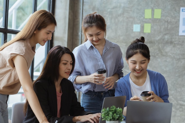 Eine Gruppe junger asiatischer Geschäftsfrauen steht und redet. Eröffnen Sie gemeinsam ein Start-up-Unternehmen und einen Businessplan-Managementplan, um das Geschäft auszubauen und durch das Konzept der neuen Generation profitabel zu werden