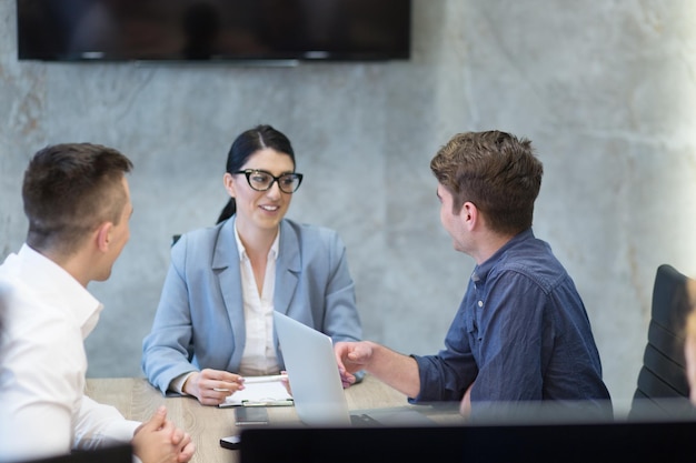 Eine Gruppe junger Geschäftsleute diskutiert einen Geschäftsplan in einem modernen Start-up-Bürogebäude