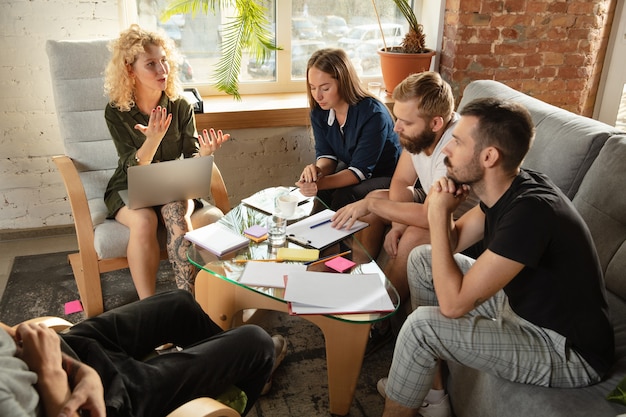 Eine Gruppe junger kaukasischer Büroangestellter hat ein kreatives Treffen, um neue Ideen zu diskutieren