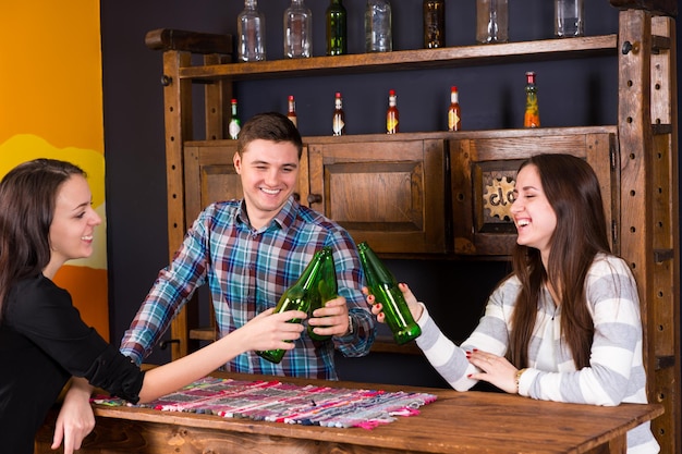 Eine Gruppe junger Leute, die an der Bar der mexikanischen Bar Bierflaschen anstoßen