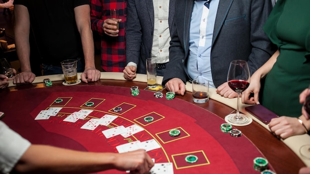 Eine Gruppe junger Leute spielt Pokerroulette am Tisch Freunde spielen im Casino Glücksspiel