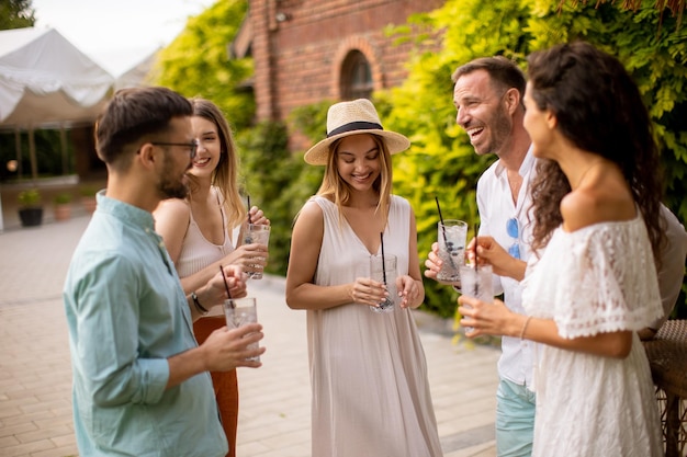 Eine Gruppe junger Leute versammelt sich im Freien, um die Gesellschaft der anderen und ein erfrischendes Glas Limonade zu genießen