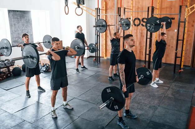 Eine Gruppe junger Sportler hat einen Crossfit-Tag drinnen im Fitnessstudio