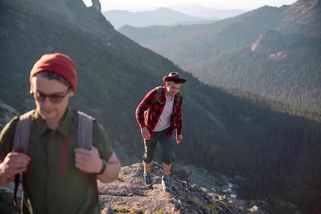 Eine Gruppe junger Touristen mit Rucksäcken in den Bergen geht die Route entlang