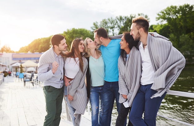 Eine Gruppe junger und erfolgreicher Menschen im Urlaub am Pier in der Sonne.