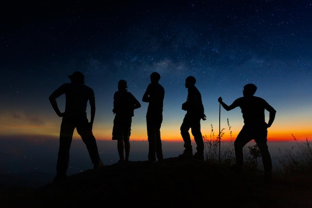 Eine Gruppe junger Wanderer beobachtet einen Sonnenuntergang auf einem Berg. Nationalpark in Thailand