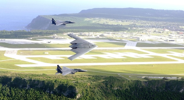 Eine Gruppe Kampfflugzeuge fliegt über eine Landebahn mit einem Berg im Hintergrund.