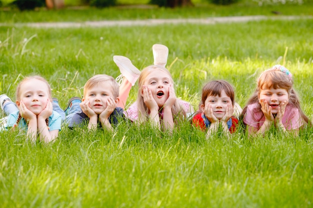 Eine Gruppe Kinder, die in den Park auf einem grünen gozon spielen und laufen.