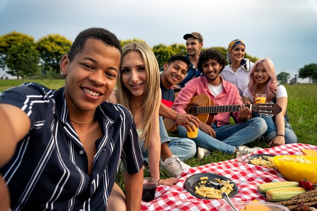 Eine Gruppe multiethnischer Teenager verbringt Zeit im Freien bei einem Picknick im Park