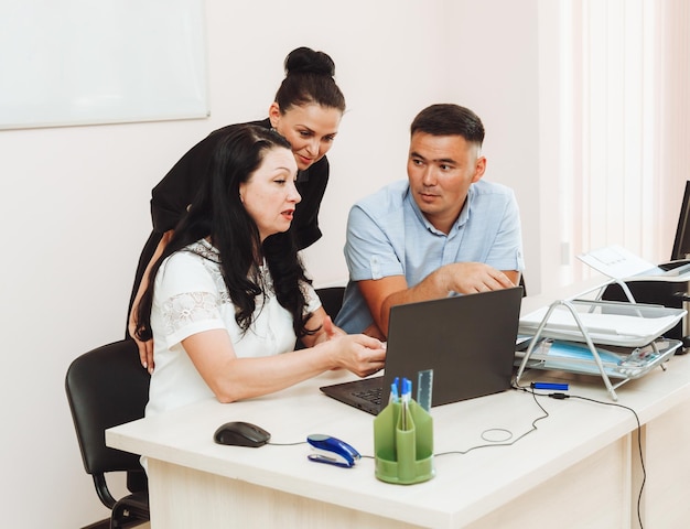 Eine Gruppe multinationaler Geschäftsleute, die in einem modernen Büro arbeiten, arbeiten im Büro am Computer