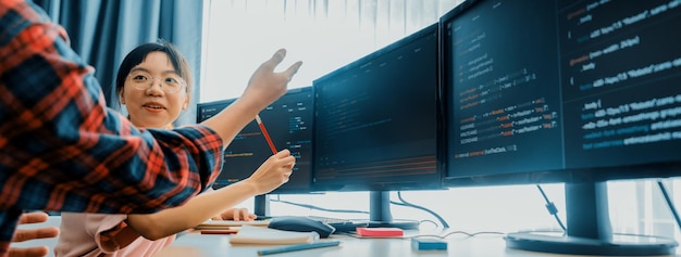 Eine Gruppe professioneller Web-Entwickler diskutiert über Datenanalyse, während der Computerbildschirm Computercode in einem modernen Büro zeigt Close Up Digital Engineering und Web-Entwicklungskonzept Burgeoning