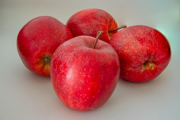 Eine Gruppe roter Äpfel befindet sich auf einer weißen Fläche