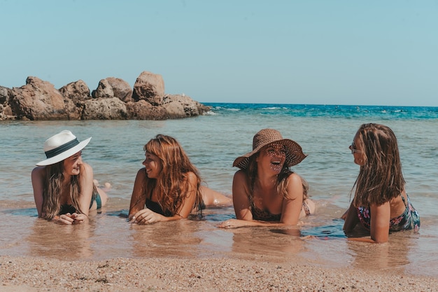 Eine Gruppe schöner junger Frauen ruht sich am Strand aus.