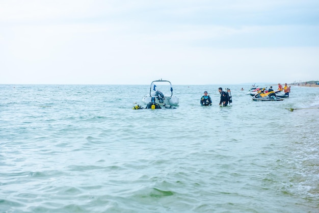 Eine Gruppe Taucher in voller Ausrüstung mit Sauerstoffflaschen betritt das Wasser an der Schwarzmeerküste