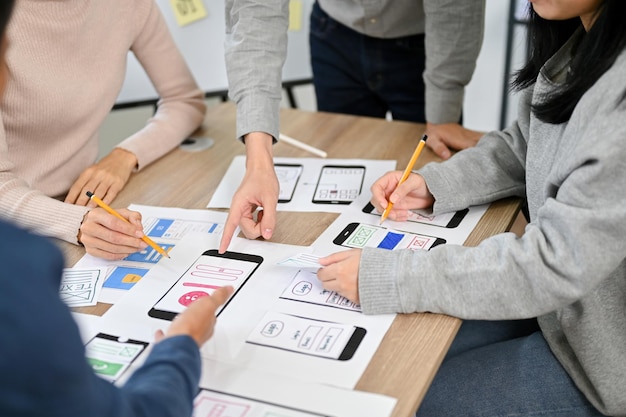 Eine Gruppe tausendjähriger asiatischer Startup-Entwickler mobiler Anwendungen befindet sich im beschnittenen Bild des Meetings