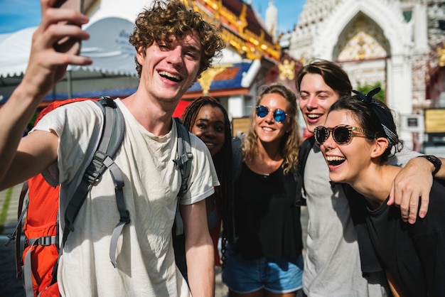 Eine Gruppe verschiedene Touristen, die selfie vor einem thailändischen Tempel, Thailand nehmen