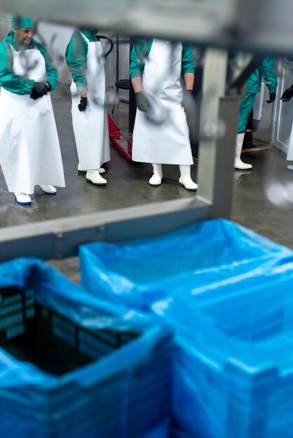 Eine Gruppe von Arbeitern in einer Fabrik mit blauen Plastikplanen auf dem Boden