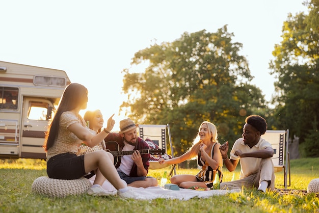 Eine Gruppe von College-Freunden verbringt Zeit miteinander und singt inmitten der Natur