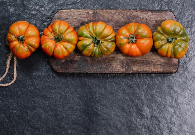 Eine Gruppe von Costoluto großen Tomaten auf einem rustikalen Konzeptraum aus Holzhintergrund für Text