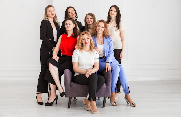 Eine Gruppe von Frauen im Business-Stil steht zusammen und posiert vor der Kamera.