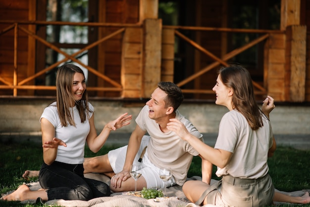 Eine Gruppe von Freunden bei einem Picknick im Wald, die Spaß haben