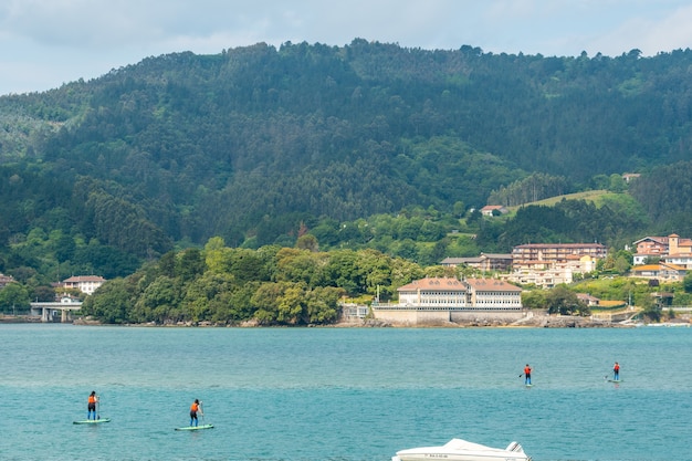 Eine Gruppe von Freunden beim Paddeln im Meer in Urdaibai, einem Biosphärenreservat Bizkaias neben Mundaka. Baskenland