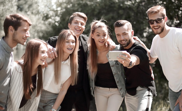 Eine Gruppe von Freunden macht ein Selfie auf dem Hintergrund der Stadt Parkmenschen und Technologie