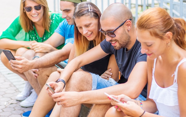 Eine Gruppe von Freunden schaut sich ein Smartphone an