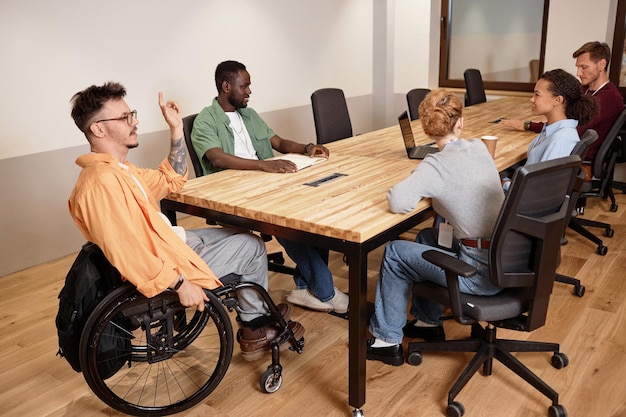 Eine Gruppe von Geschäftsleuten, die während eines Treffens im Sitzungssaal an einem Tisch miteinander sprechen