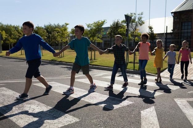 Eine Gruppe von Grundschülern überquert eine Straße