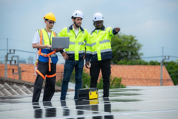 Eine Gruppe von Ingenieuren und Technikern inspiziert die Installation von Solarmodulen und testet den Betrieb