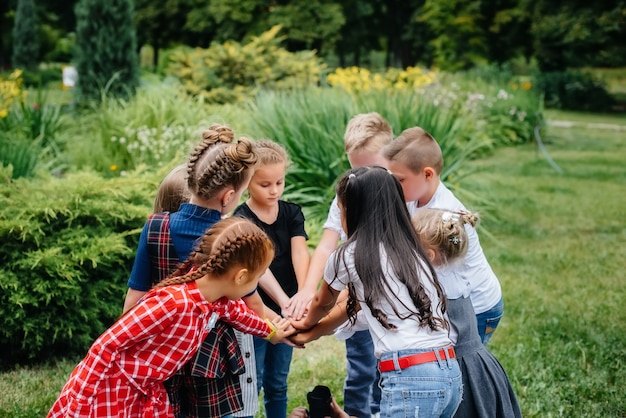 Eine Gruppe von Kindern läuft herum, hat Spaß und spielt im Sommer als größeres Team im Park. Glückliche Kindheit.