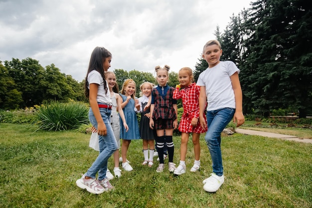 Eine Gruppe von Kindern tobt, hat Spaß und spielt im Sommer als größeres Team im Park. Glückliche Kindheit.