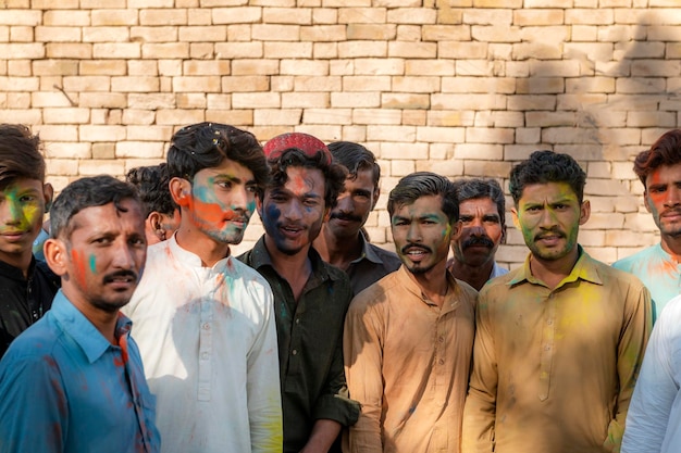 Foto eine gruppe von männern mit farbigem puder im gesicht steht vor einer wand.