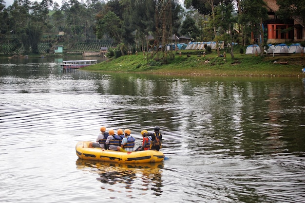 Eine Gruppe von Menschen fährt mit einem gelben Floß auf einem Fluss.