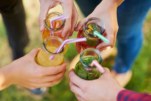 Eine Gruppe von Menschen feiert mit Detox-Saft-Cocktails auf grüner Natur