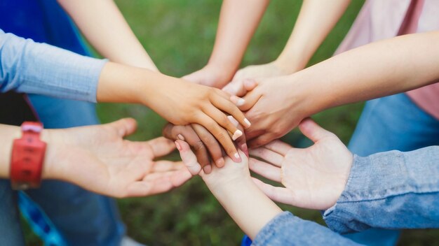 eine Gruppe von Menschen mit Händen um einander, von denen einer einen Kreis hält