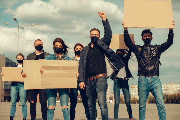 Eine Gruppe von Menschen mit Maske und Plakaten zum Protest Der Protest der Bevölkerung gegen das Coronavirus